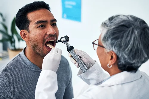 dentist performing oral cancer screening on patient