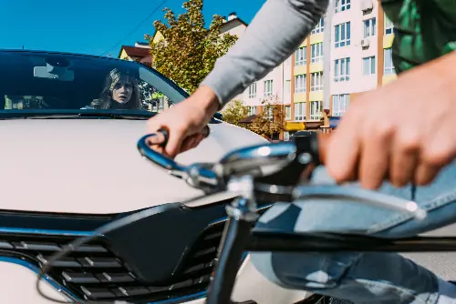 Image of a bicycle accident between a motorist in a Lincoln SUV and a man on a classic bicycle