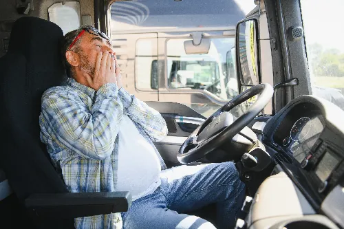 Tired truck driver in cab of 18-wheeler