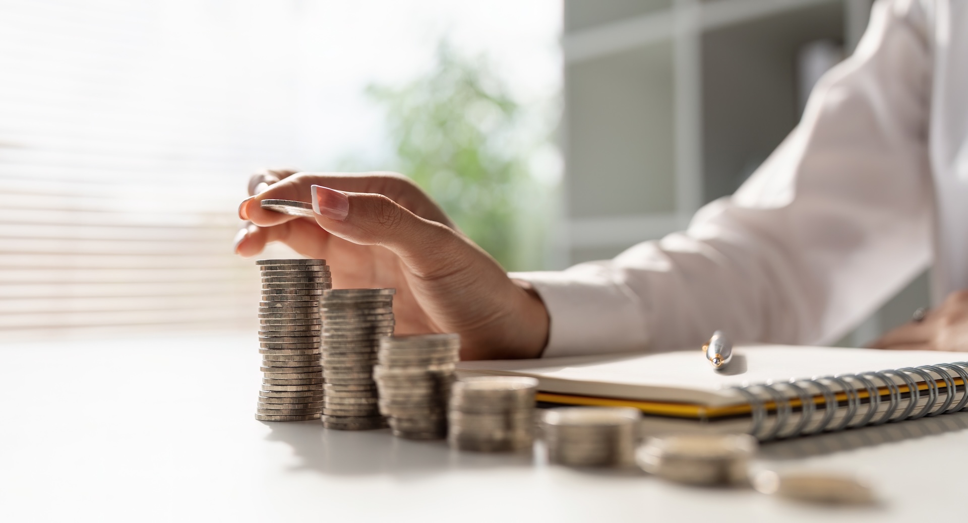 Young woman making stack of coins.