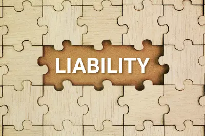 liability spelled within a wooden puzzle