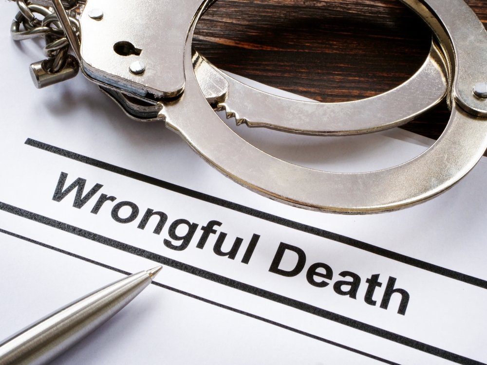 Document labeled “Wrongful Death” next to handcuffs and a pen, symbolizing legal accountability for negligence in a Florida rehab center.