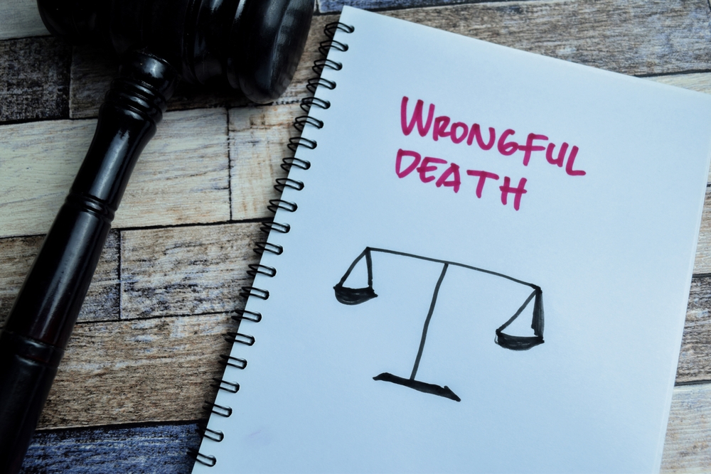 Notebook showing a justice scale and the words “Wrongful Death,” representing legal action after a psychiatric facility death.